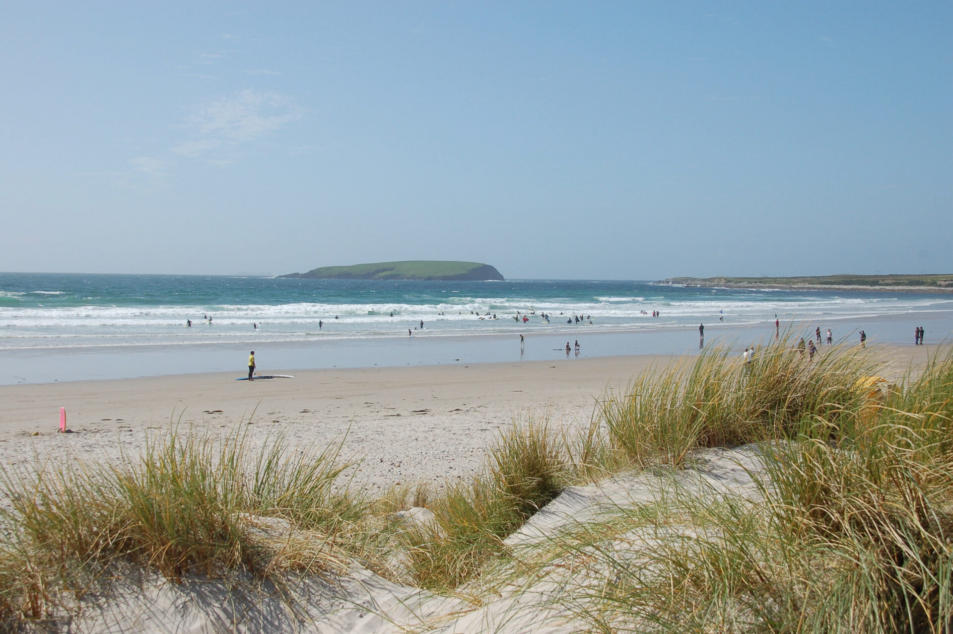 Dünen mit Küste voller Surfer auf Achill Island in Irland