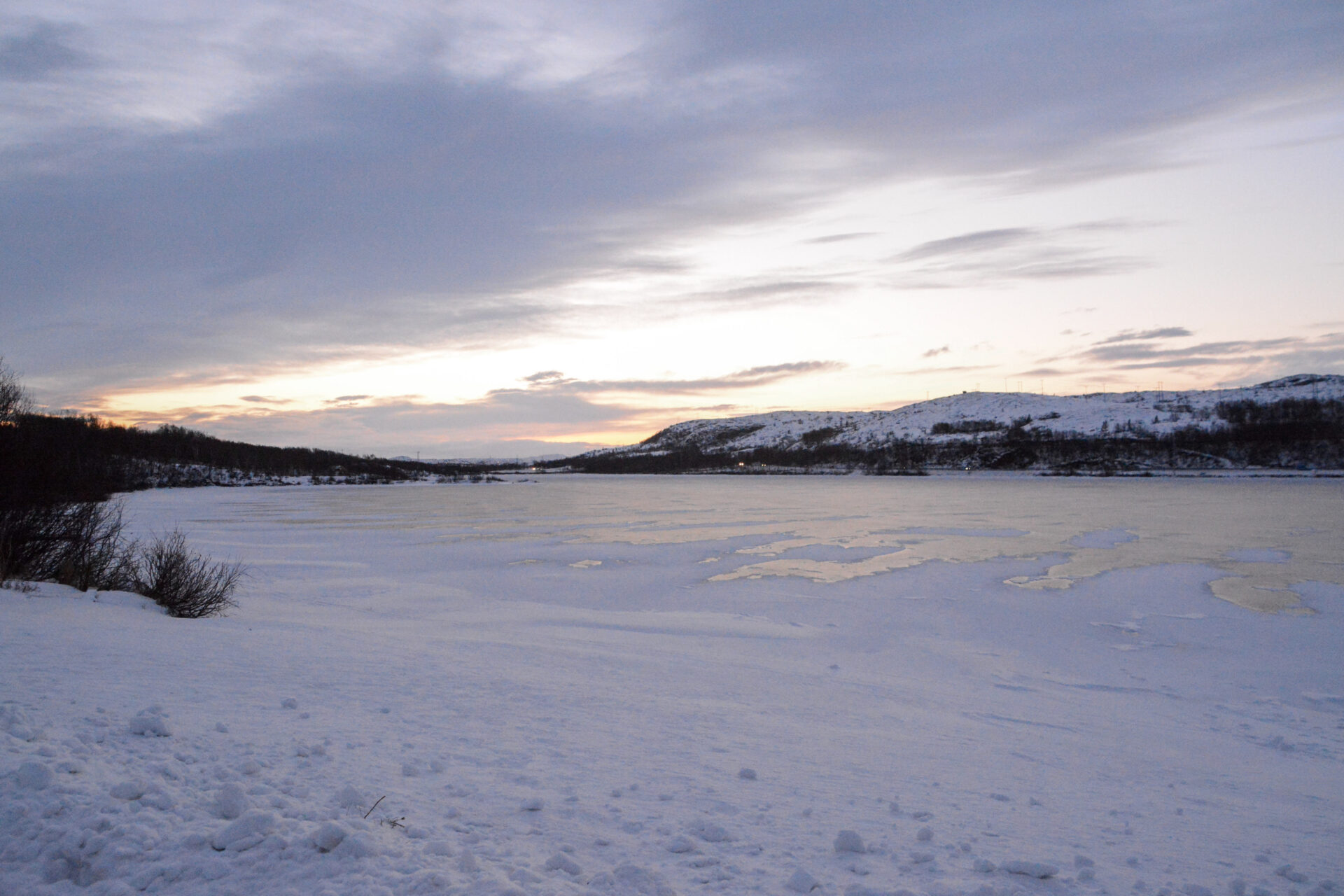 Zugefrorener See am lichtarmen Mittag während der Polarnacht in Kirkenes