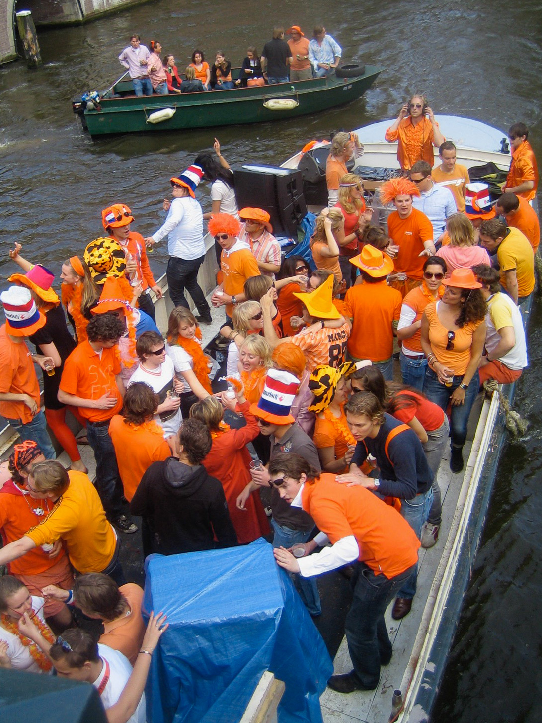 Boot voller orange gekleideter Menschen beim Königstag in Amsterdam