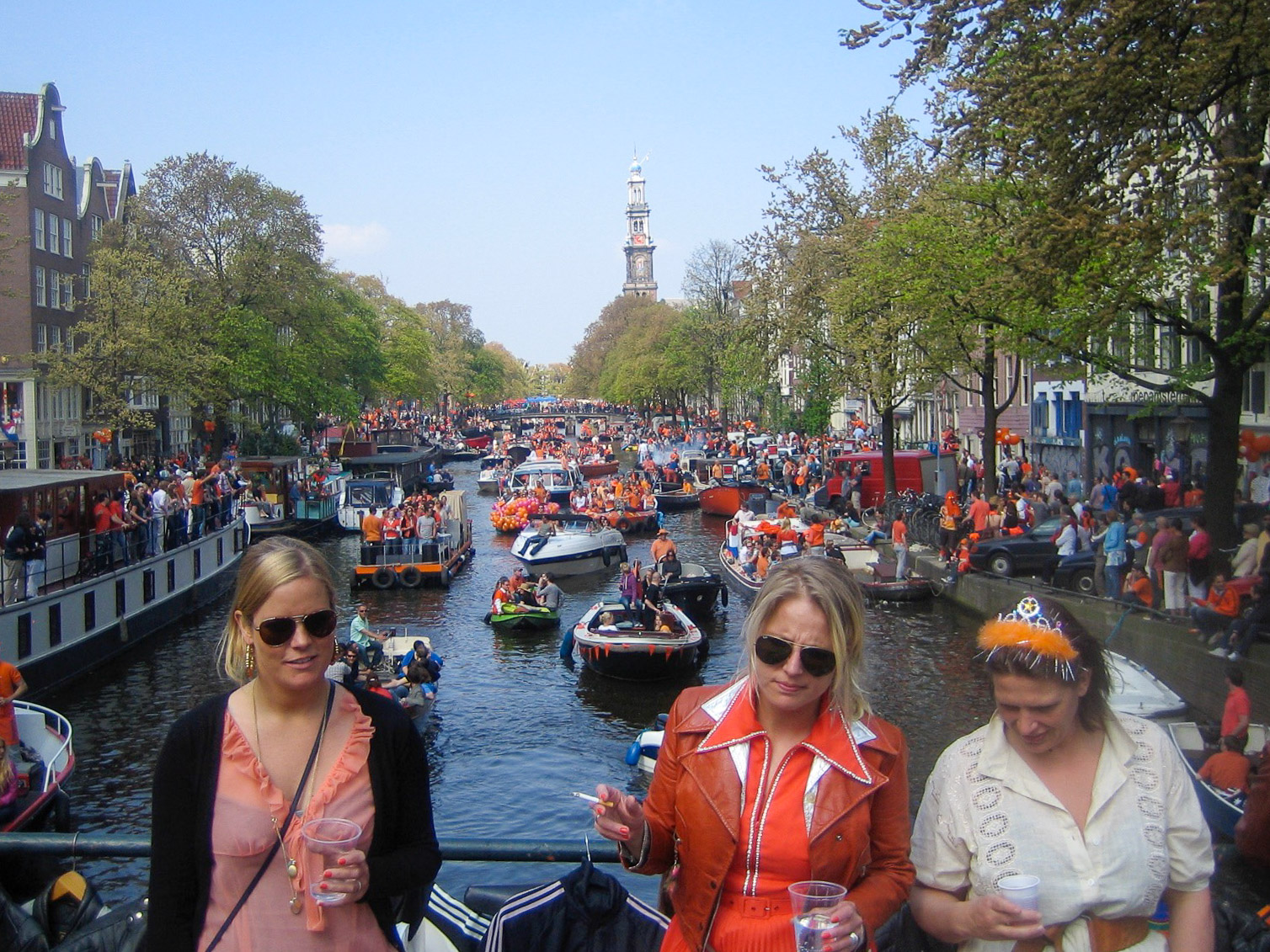 Drei feiernde Frauen auf einer Brücke in Amsterdam Prinsengracht Westerkerk