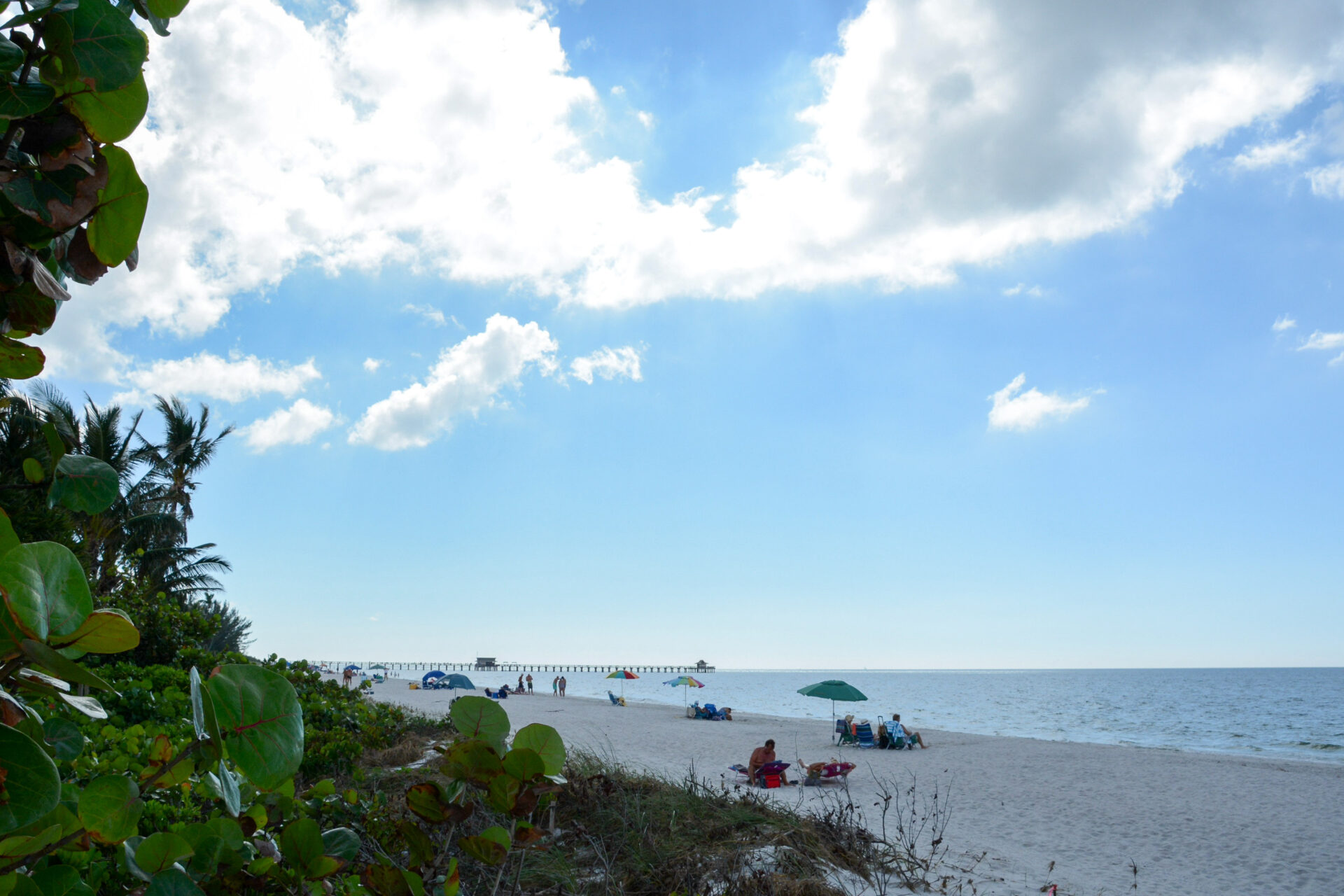 Strandleben an einem Wintertag in Naples im US-Bundesstaat Florida mit ein paar Menschen und einem Pier im Hintergrund