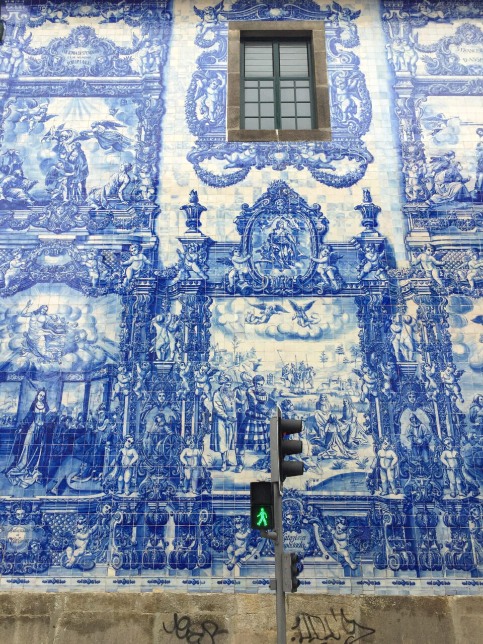 Blau gekachelte Fassade in Porto mit grüner Fußgängerampel davor