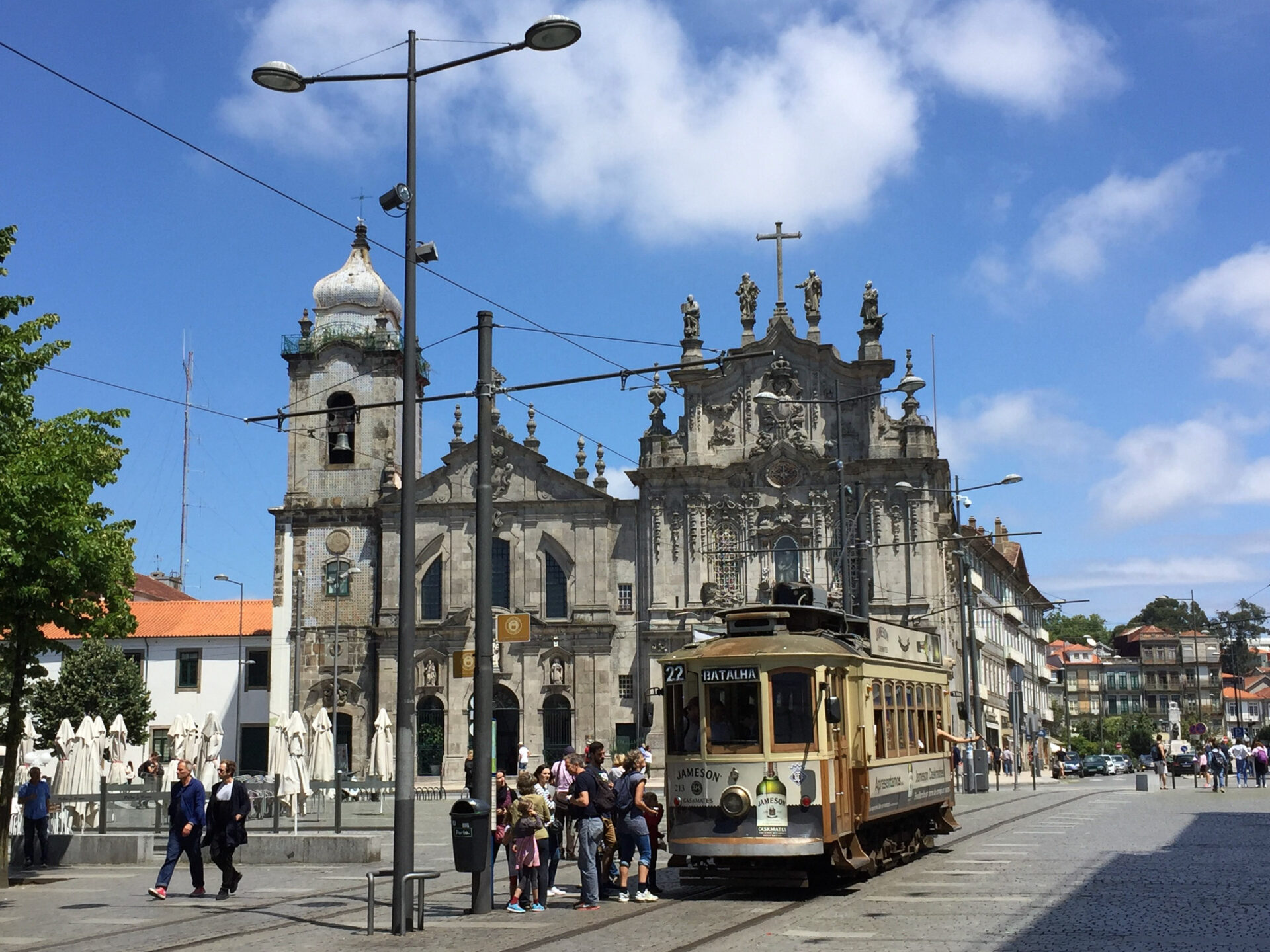 Historische Straßenbahn mit alten Kirchen in Porto