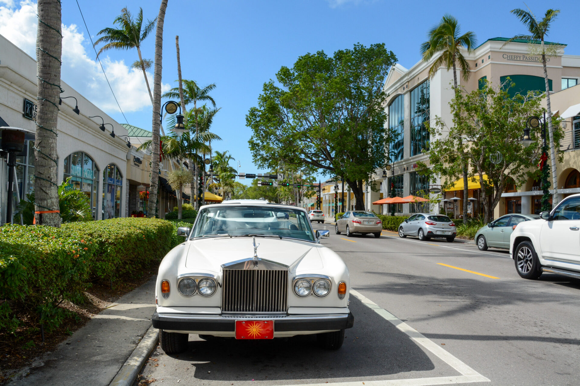 Ein parkender Rolls Royce Cabrio vor Palmen auf der Fifth Avenue in Naples in US-Bundesstaat Florida