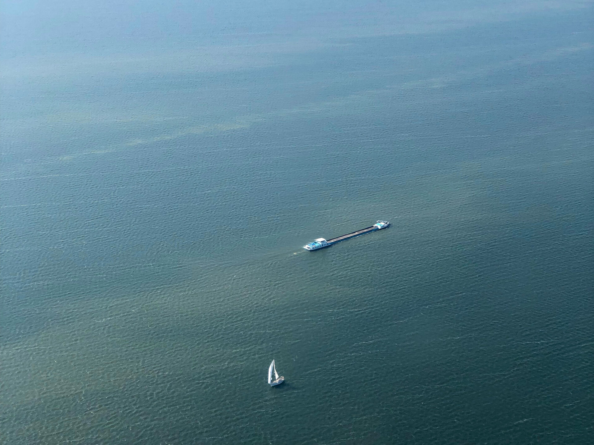 Segelboot und Frachtschiff treffen sich im Ijsselmeer Luftaufnahme