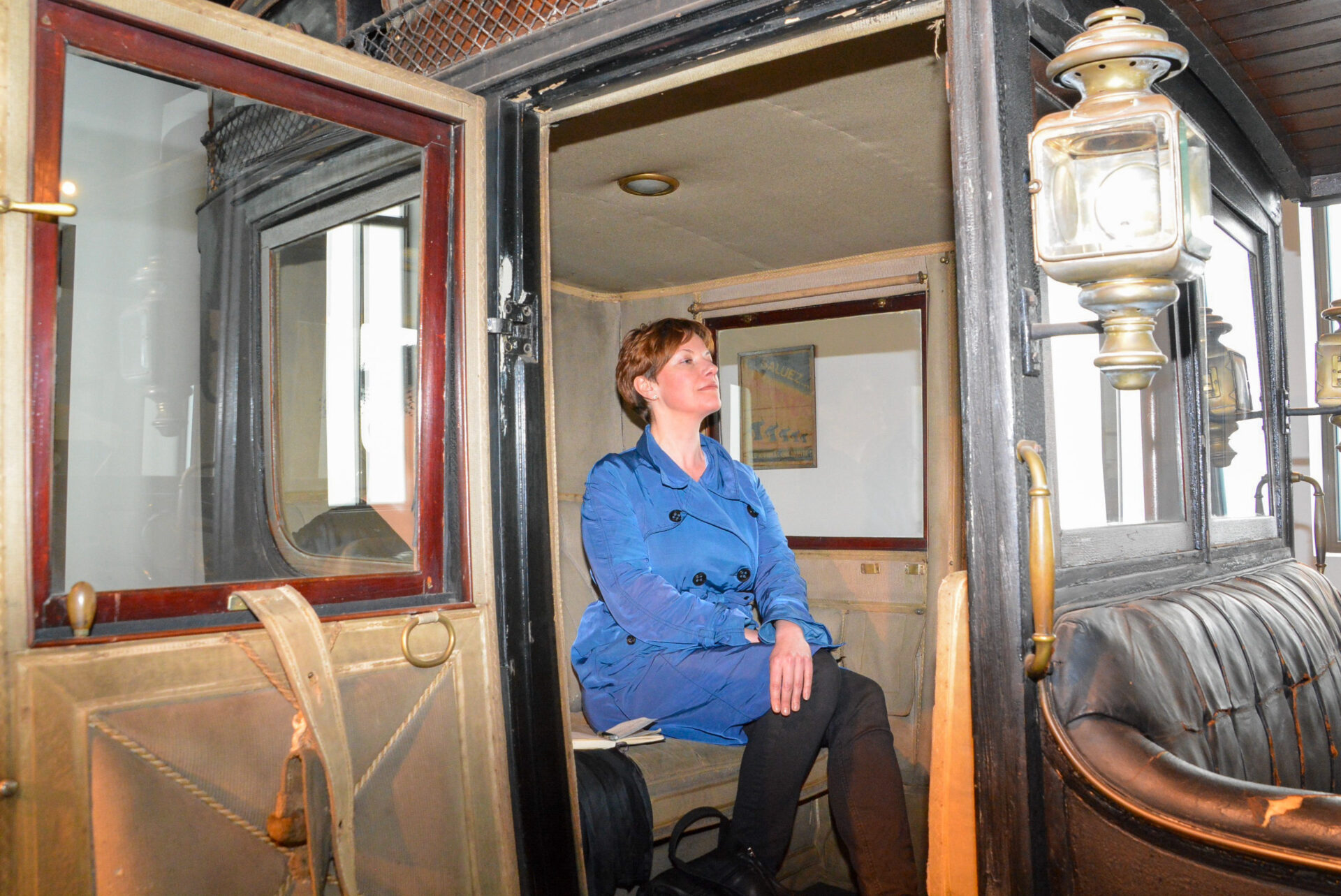 Frau in einem Oldtimer mit offenem Fahrerhaus im Automuseum von Málaga