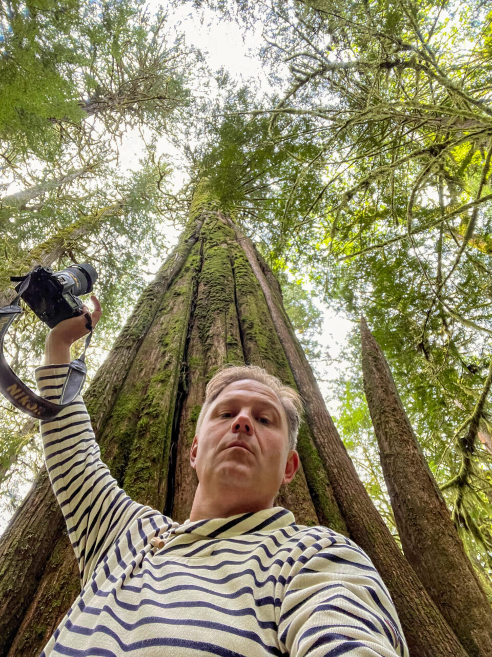 Autor Ralf Johnen mit Kamera vor einem Mammutbaum im Olympic National Park im Nordwesten der USA