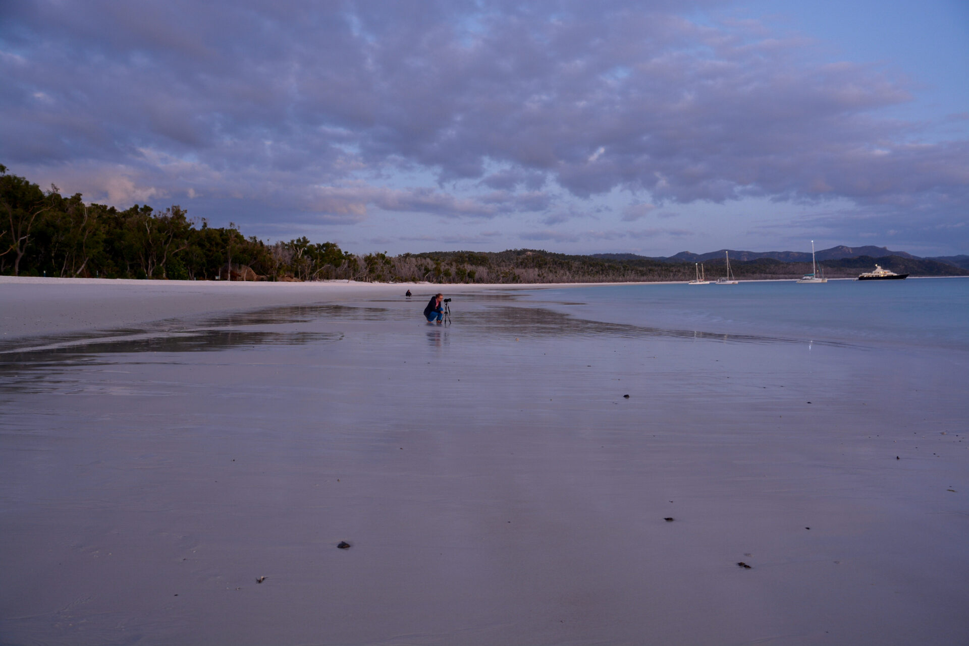 Frau mit Kamera am Whitehaven Beach in den Whitsunday Islands im australischen Queensland