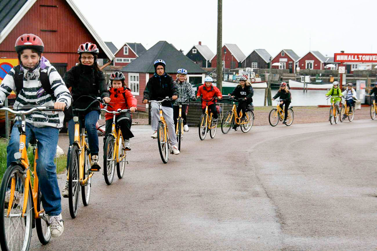 Radelnde Schulkinder mit Helm auf der Insel Ven