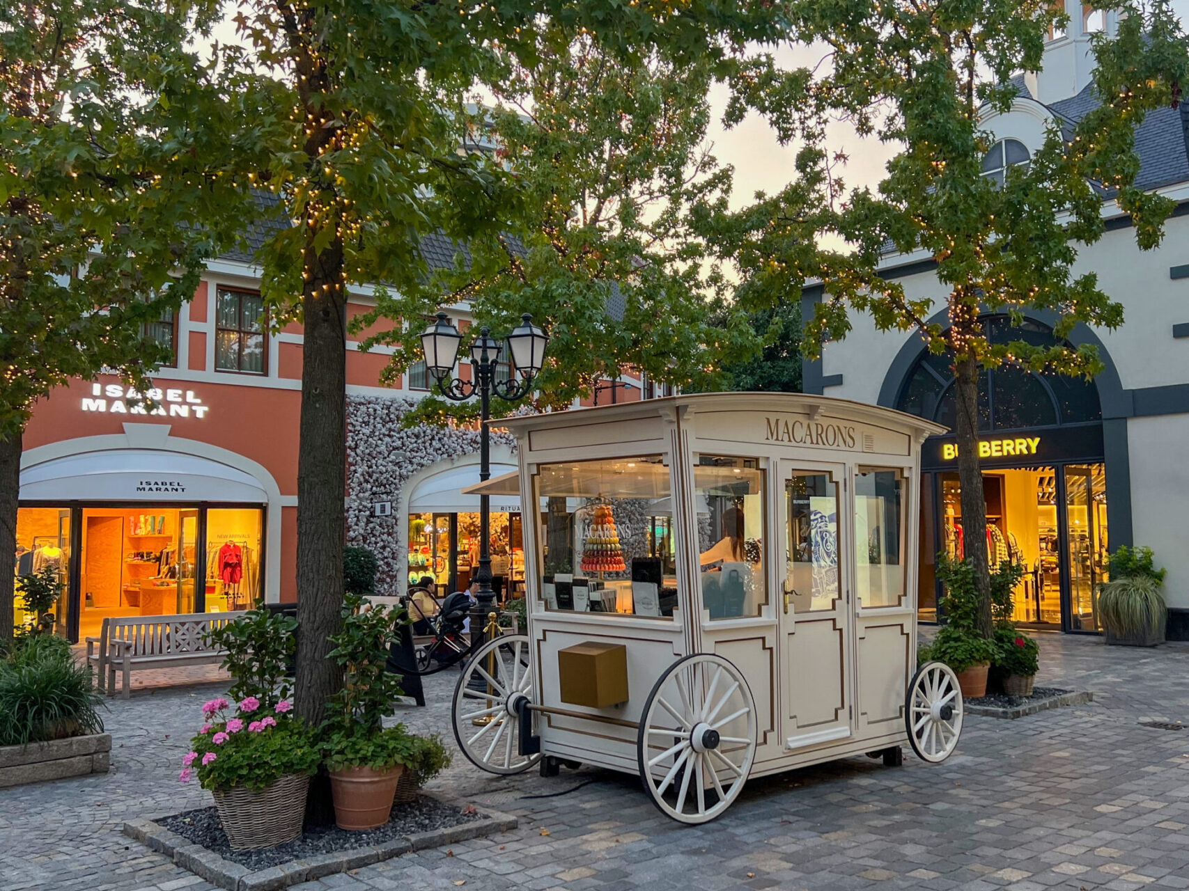 Wagen zum Verkauf von Macarons vor Geschäften im Outlet Center Roermond