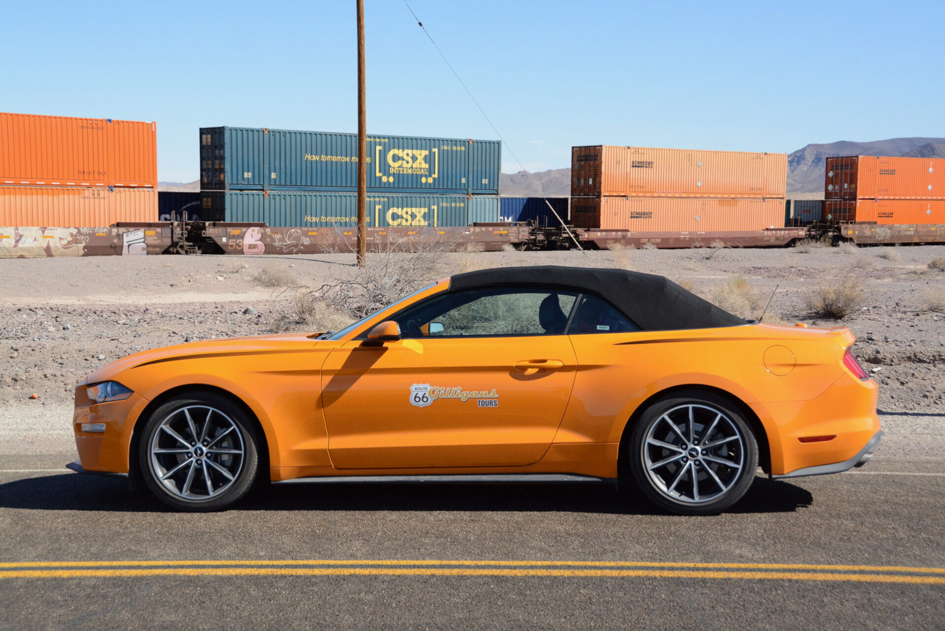 Ford Mustang vor einem Güterzug an der Route 66