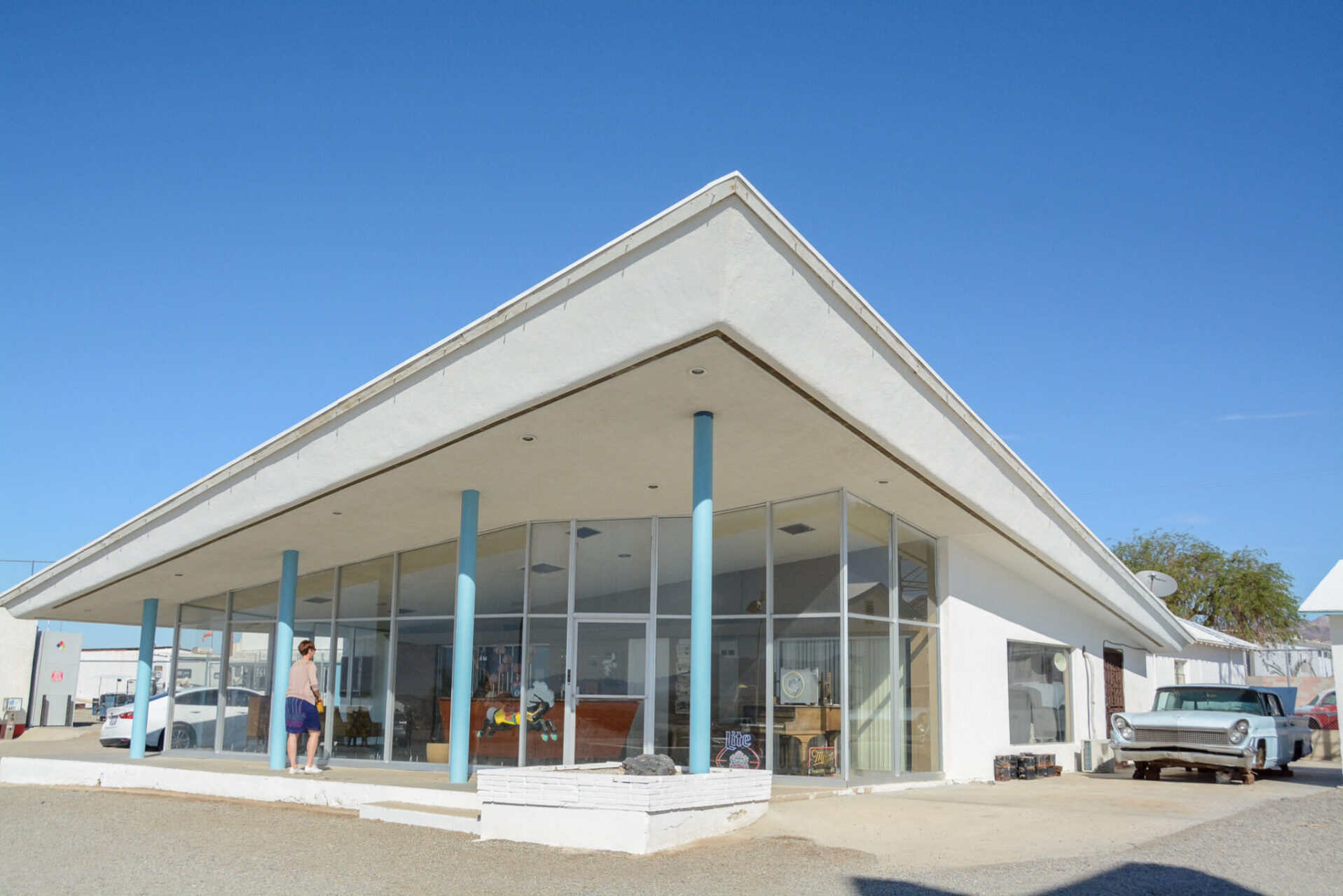 Oltimer mit Heckflossen und leerstehendem Gebäude bei Roy's Motel