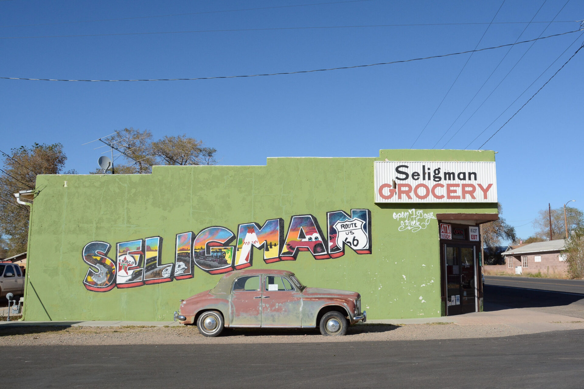 Mural mit Schriftzug des Ortes Seligman mit Oldtimer