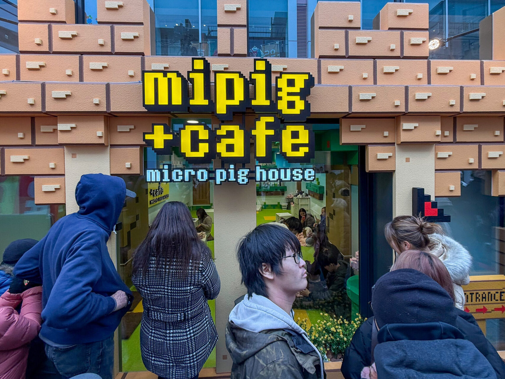Passanten vor dem Mipig Cafe im Stadtteil Shinjuku in Tokio
