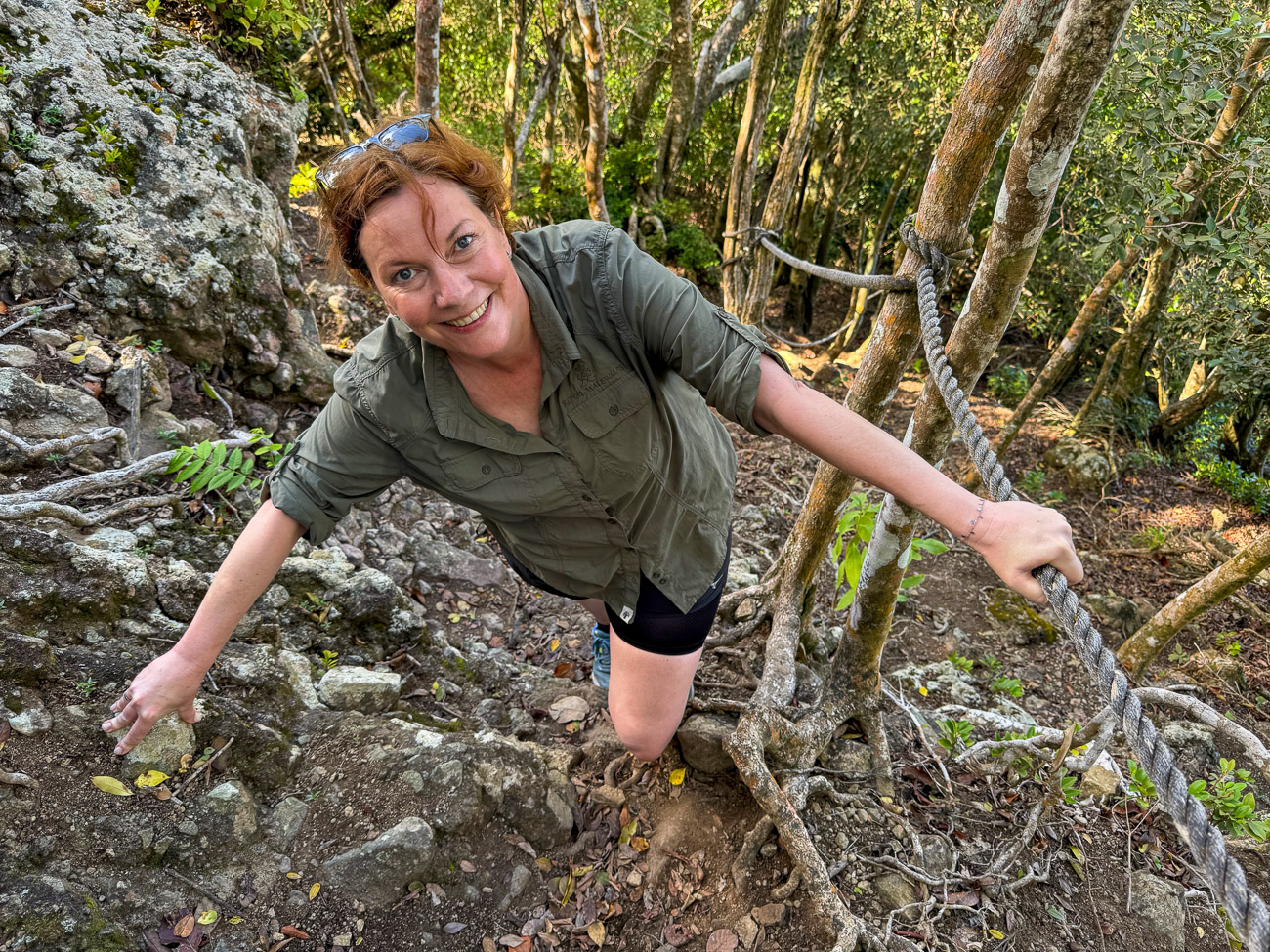 Junge Frau klettert an Seilen den Vulkan Quill auf Sint Eustatius hinauf