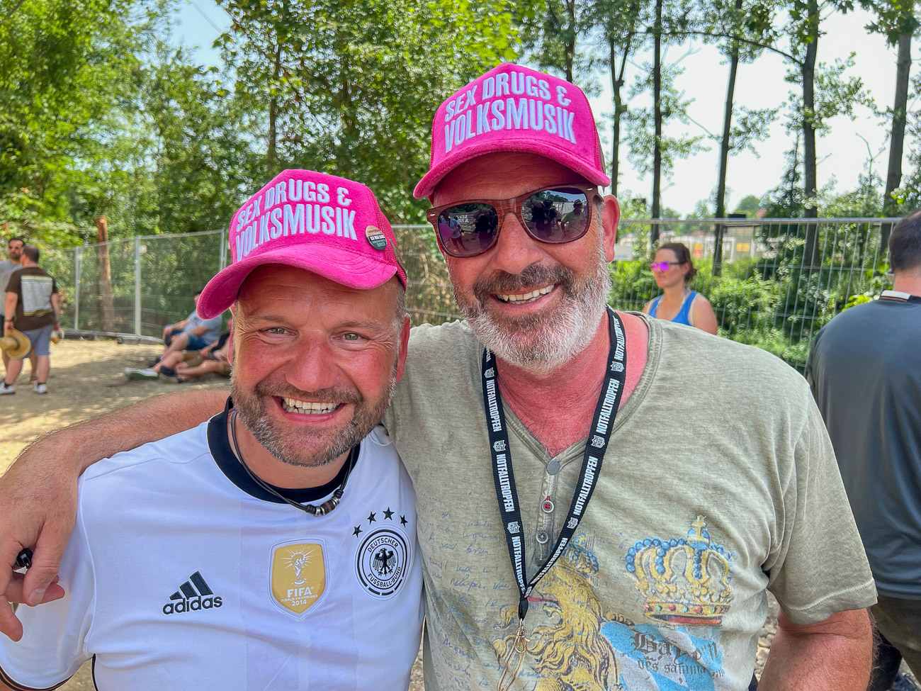 Zwei Besucher des Festivals Woodstock der Blasmusik tragen Kappen mit der Aufschrift »Sex, Drugs & Blasmusik«