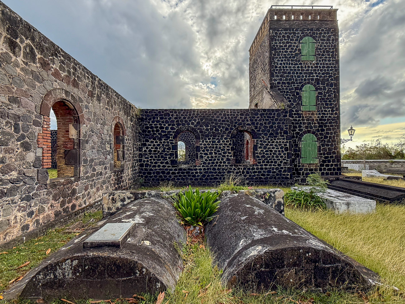 Betrongräber und Kirche mit wilder Kliwia auf Sint Eustatius