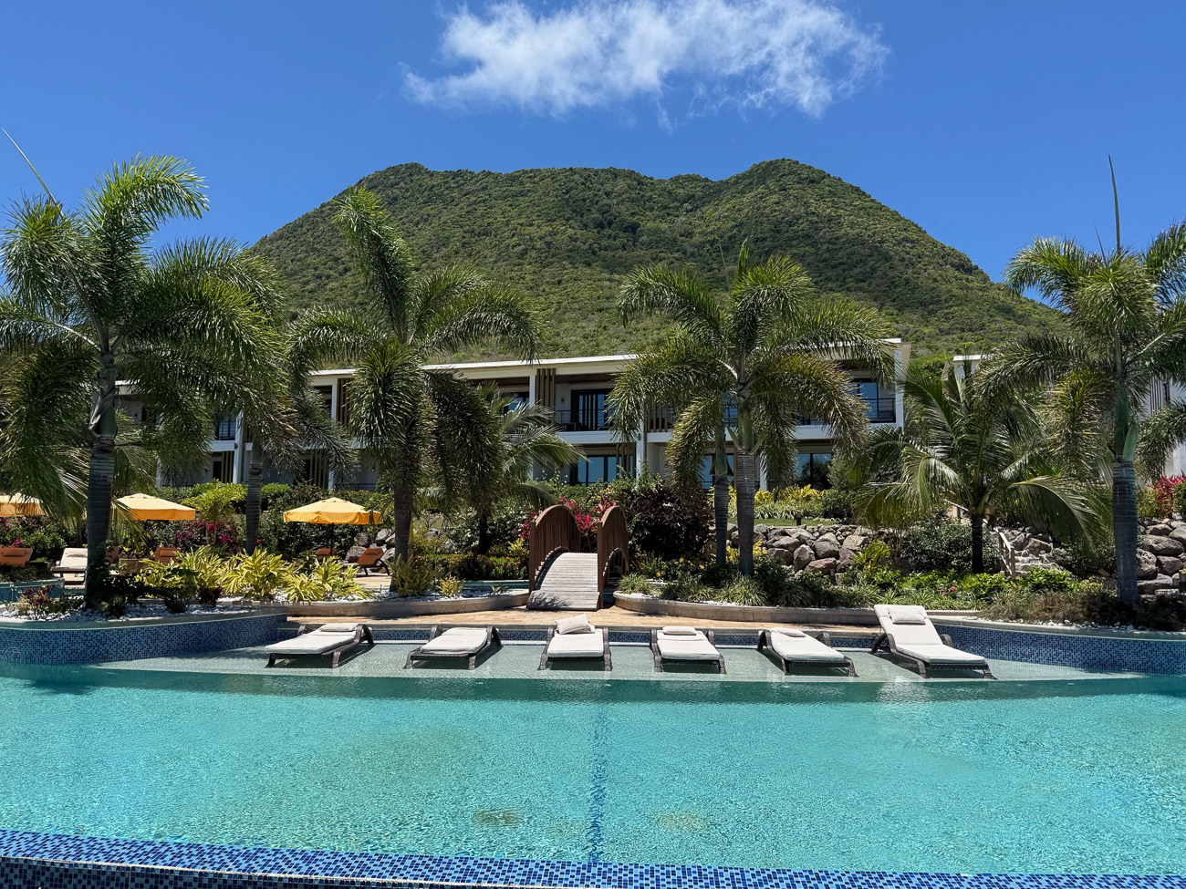 Pool mit Liegen des Golden Rock Resort vor dem Vulkan Quill