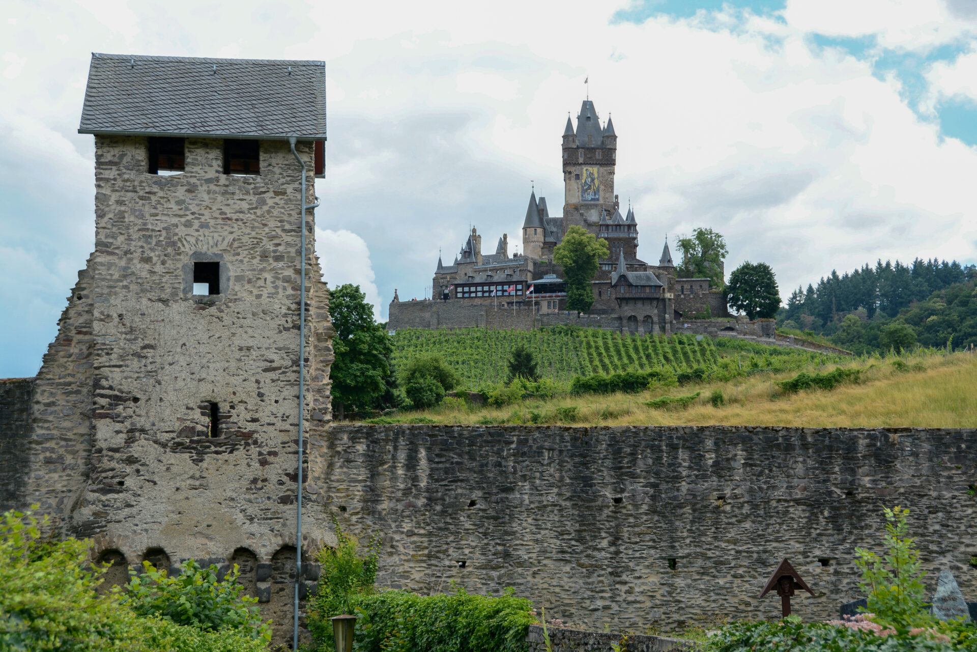 Die majästetische Reichsburg in Cochem mit der Stadtmauer und Weinbergen