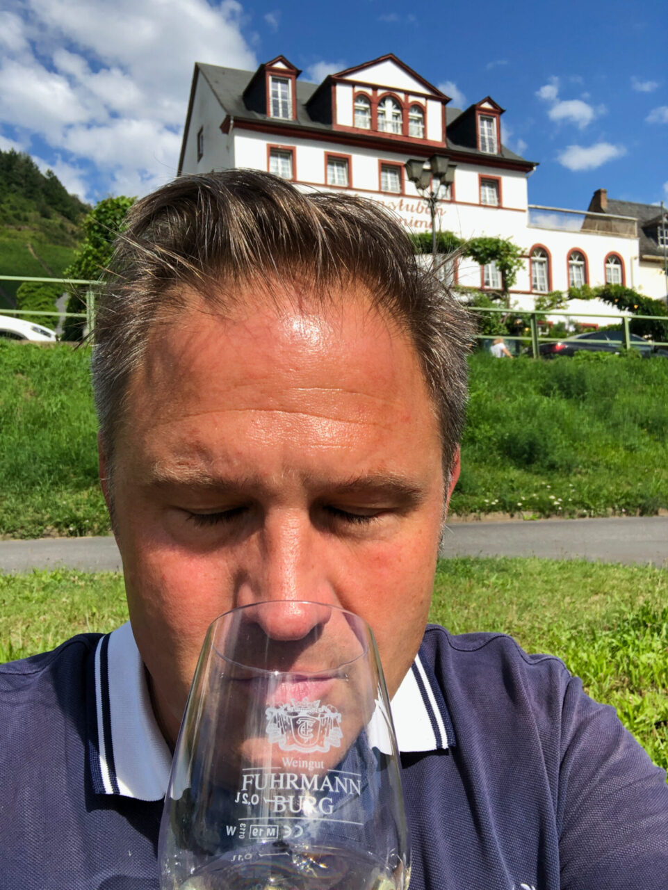 Autor Ralf riecht an einem Wein am Moselufer
