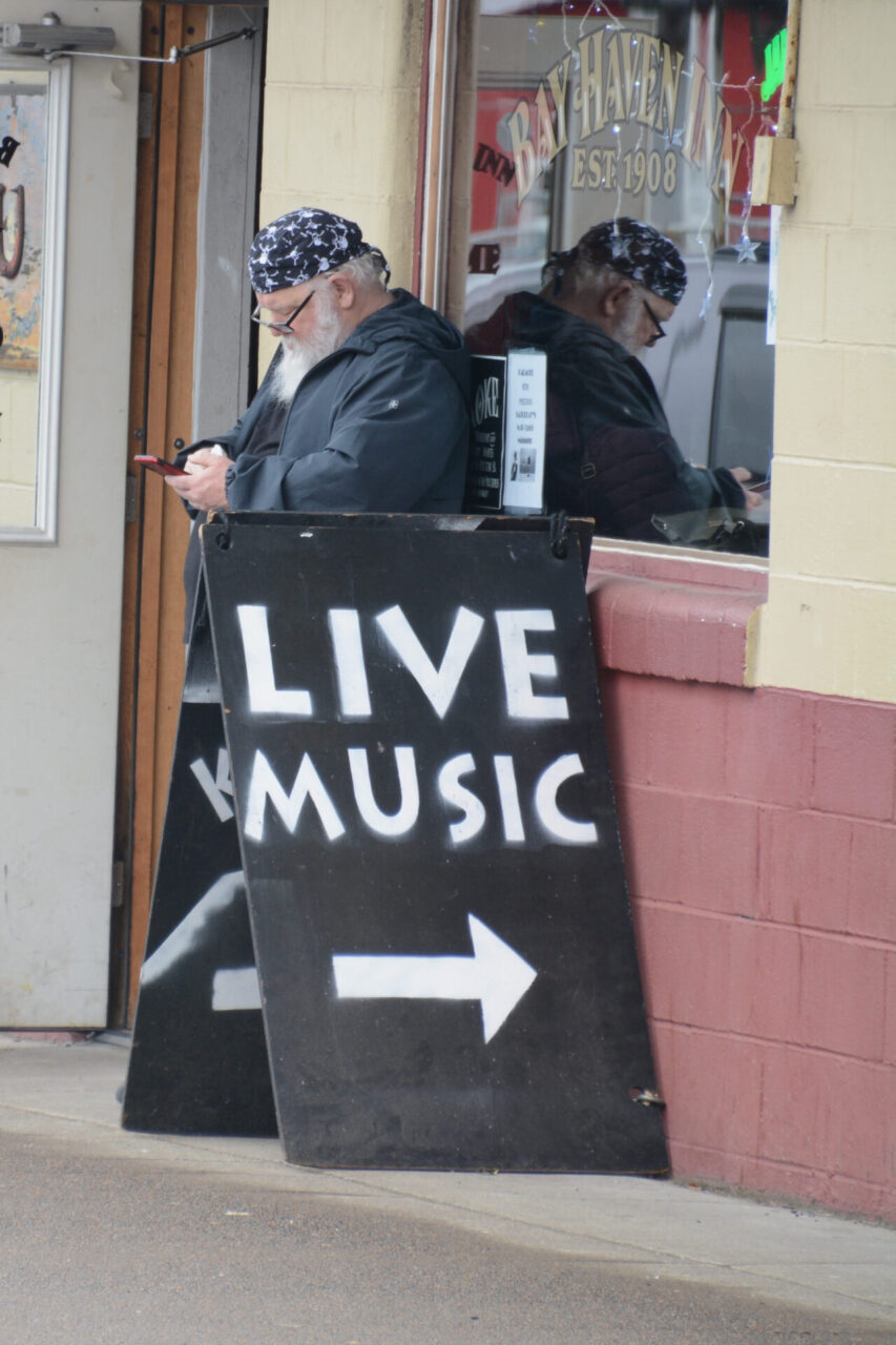 Kneipe Bay Haven in Newport in Oregon mit bärtigem Mann hinter dem Schild "Live Music"