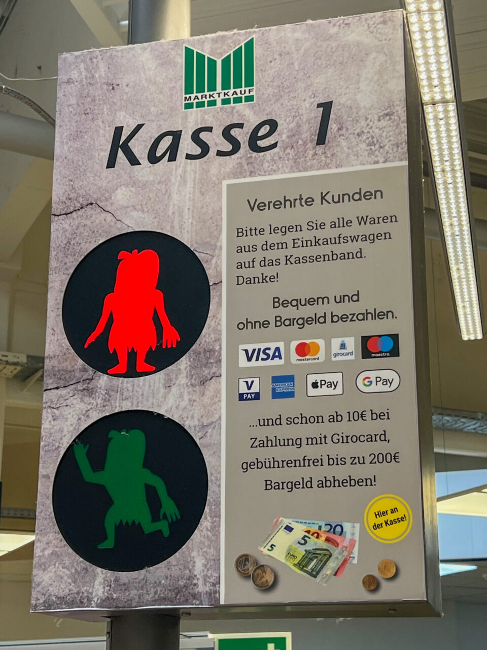 Piktogramme von Steinzeitmenschen an der Kasse eines Supermarktes in Schöningen