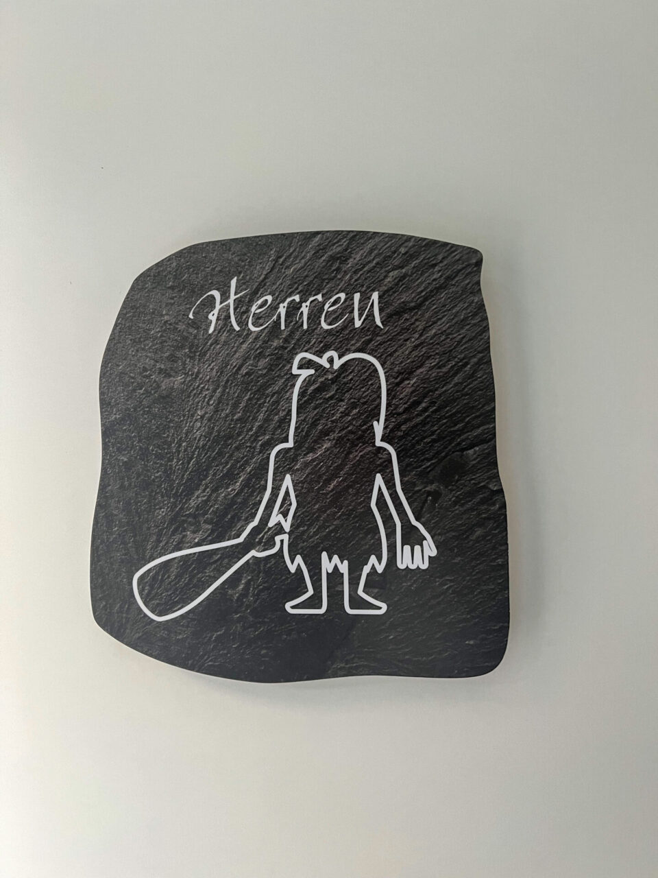 Piktogramm eines Steinzeitmenschen an der Herrentoilette eines Supermarktes im niedersächsischen Schöningen