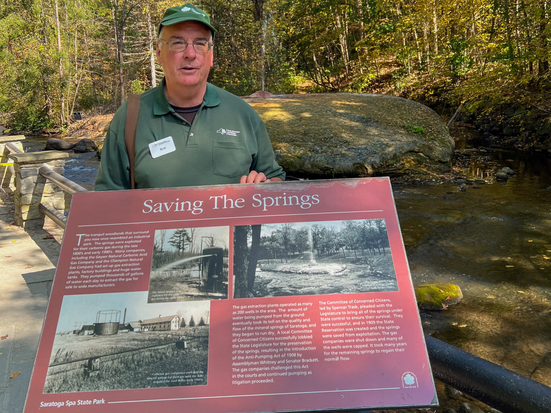 Touristenführer hinter einen Schild, das auf die Rettung der Quellen von Saratoga verweist